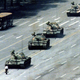 A citizen stands passively in front of a convoy of tanks on the Avenue of Eternal peace